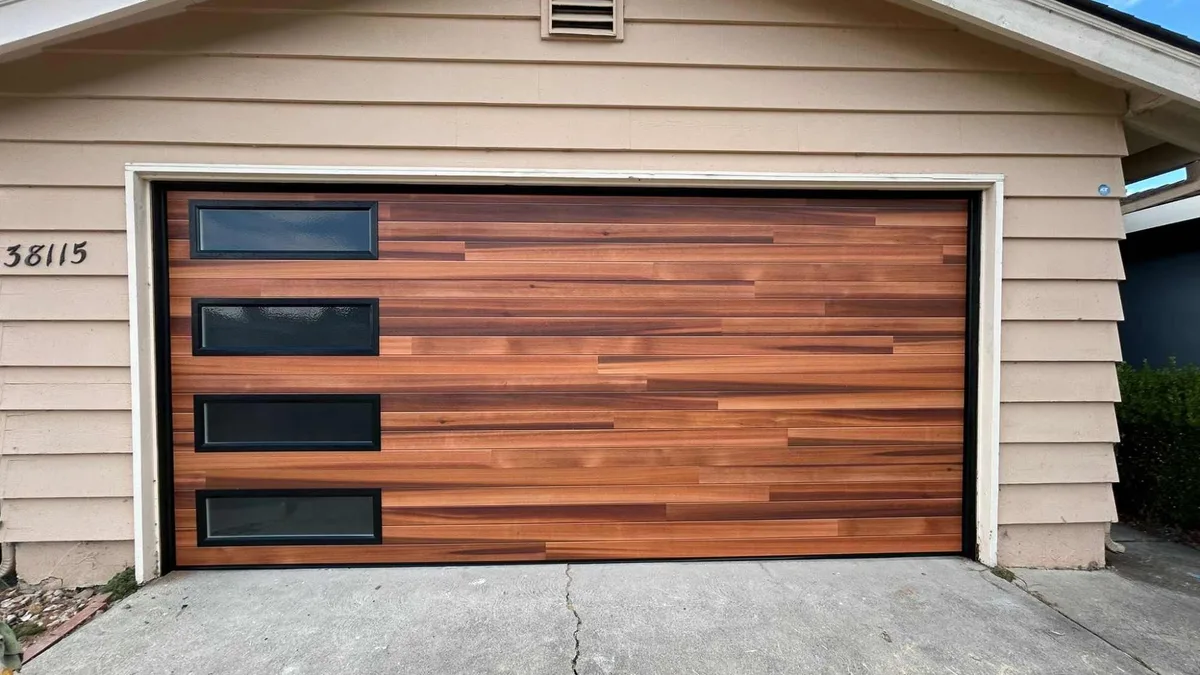 Warm cedar carriage-style garage door with a vertical stack of windows